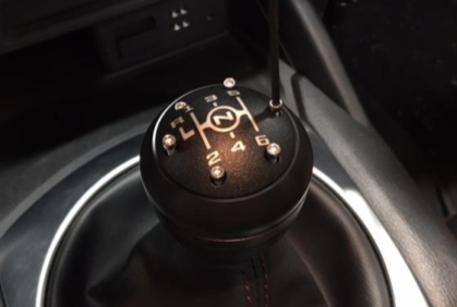 The cap being screwed into the top of the shift knob assembly with 6 screws