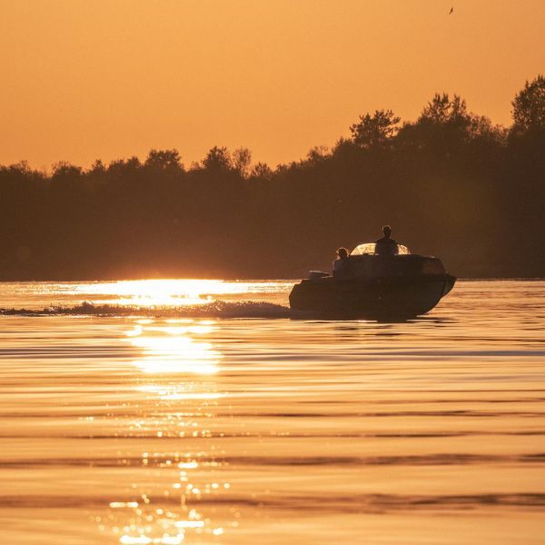 Boat on water at sunset