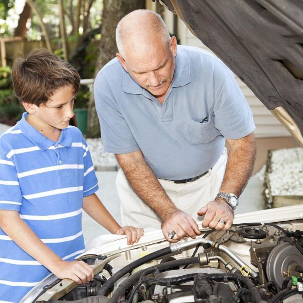 Father and son looking at car engine