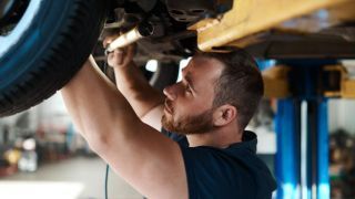 Mechanic inspecting car