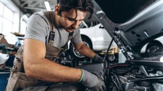 Mechanic working on car engine