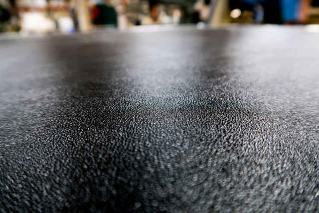 Close-up of the textured black laminate bonded to a plywood panel