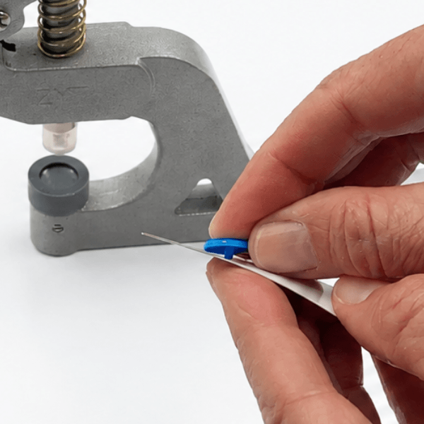 Inserting plastic snap cap through fabric