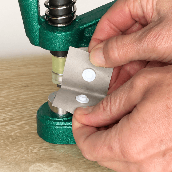 Applying the second half of a plastic snap
