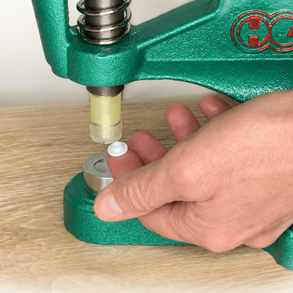Positioning plastic snap cap in the lower die