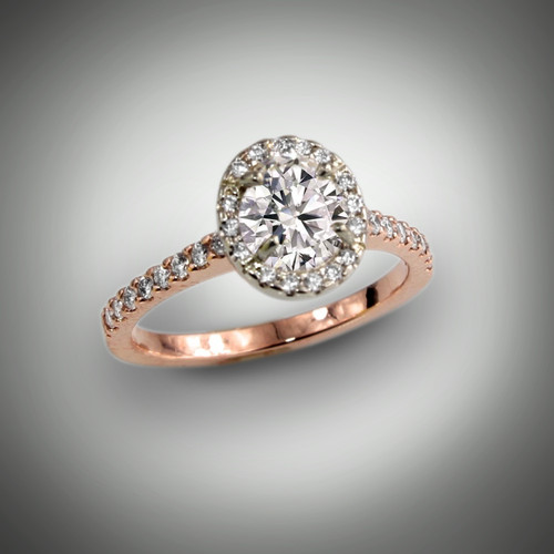 This custom engagement ring has a 0.91ct oval brilliant H/SI2 center stone with a halo of 24 pave` F/VS diamonds of 16 points all set in white gold.  The band has 18 pave` F/VS of 12 points set in 14kt rose gold.