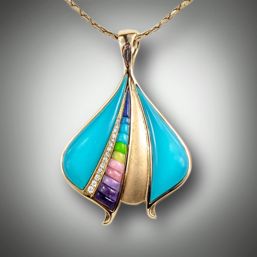 Pnd 246 has two pieces of Sleeping Beauty turquoise, row of .15 points of pave` diamonds, with hand carved inlay stones of lavulite, rhodonite, verde antique, gaspeite, turquoise and lapis set in 14kt yellow gold.
