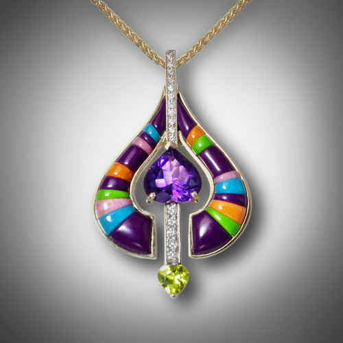 Pnd 336 long has a 10x11mm amethyst heart shaped center stone with a 6mm heart peridot stone at the bottom with two rows of F/VS pave` diamonds of 34.5 points total and hand carved purple jasper, coral, turquoise, gaspeite, and pink rhodonite set in 13.39 grams of 14kt yellow gold.
