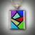 PND 433 is a beautiful Mondrian style pendant in 14kt Yellow Gold with .84 points of F/VS pave diamonds, featuring hand sculpted Turquoise, Gaspeite, Variscite, Red Fairy Jasper, Lapis, Sugilite, Verde Antique marble and Black Jade on a 14kt Yellow Gold wheat chain.