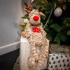Cupid & Comet Rita Reindeer stuffingless calming lavender Christmas dog toy sitting in front of christmas tree on wrapped present