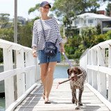 Women out walking with their dog using the DOOG walkie bag in colour navy Polka White with bag at her front left side.