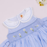 Hand-smocked bodice with delicate daisy embroidery, a classic Peter Pan collar