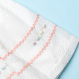 The hem features charming hand-embroidered roses.