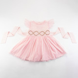 Baby pink hand-smocked embroidered dress with a soft tulle skirt.