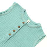 Sleeveless bubble romper in dusty blue organic muslin cotton features subtle embroidery around the neckline and armholes with a wooden button front