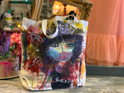 She's colorful. She's silly. She has a big head, and insists on wearing a crown! She's imperfectly perfect and she is for sure one of a kind. But she's exactly what the world needs her to be. She. Is. Fearless. So go ahead and pick up her crown.

Hand painted/ One of a kind/ Canvass tote bag