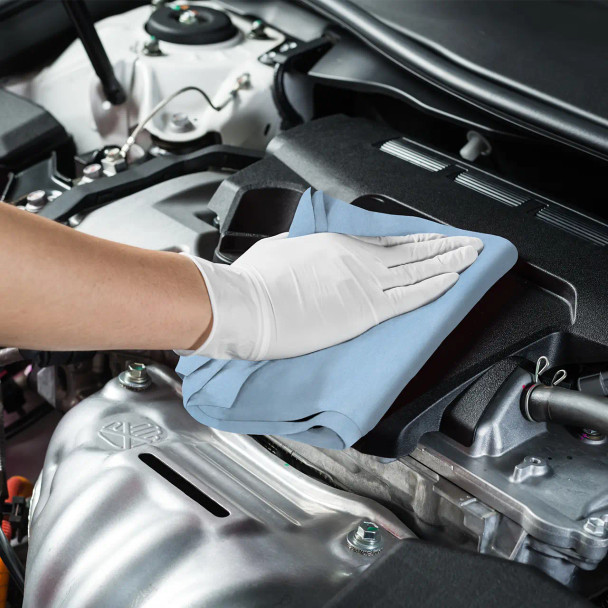 Worker using Sellars S700 Ultra Lo-Lint blue wiper to clean metal surfaces inside a car engine bay — ideal for lint-sensitive industrial maintenance tasks