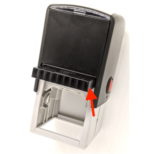 An arrow pointing to the ink pad showing how to push the pad back into the self-inking rubber stamp.