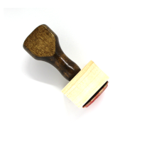 A wooden rubber stamp with a walnut handle.