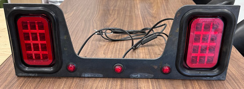 Dual Maxxima LED stop turn tail light bracket assembly for dump truck rear lighting applications with integrated marker lights and fabricated steel bracket.