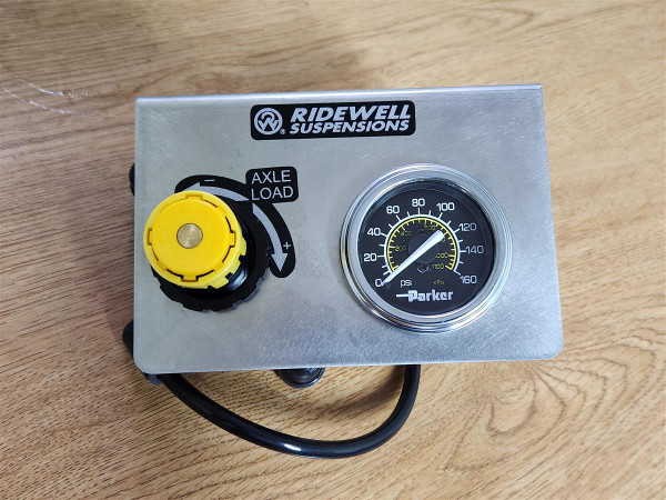 Front view of Ridewell 1210039 ACK Panel showing Parker air pressure gauge (0–160 psi) and yellow axle-load control knob for lift-axle air system regulation. Front view of Ridewell 1210039 ACK Panel showing Parker air pressure gauge (0–160 psi) and yellow axle-load control knob for lift-axle air system regulation.