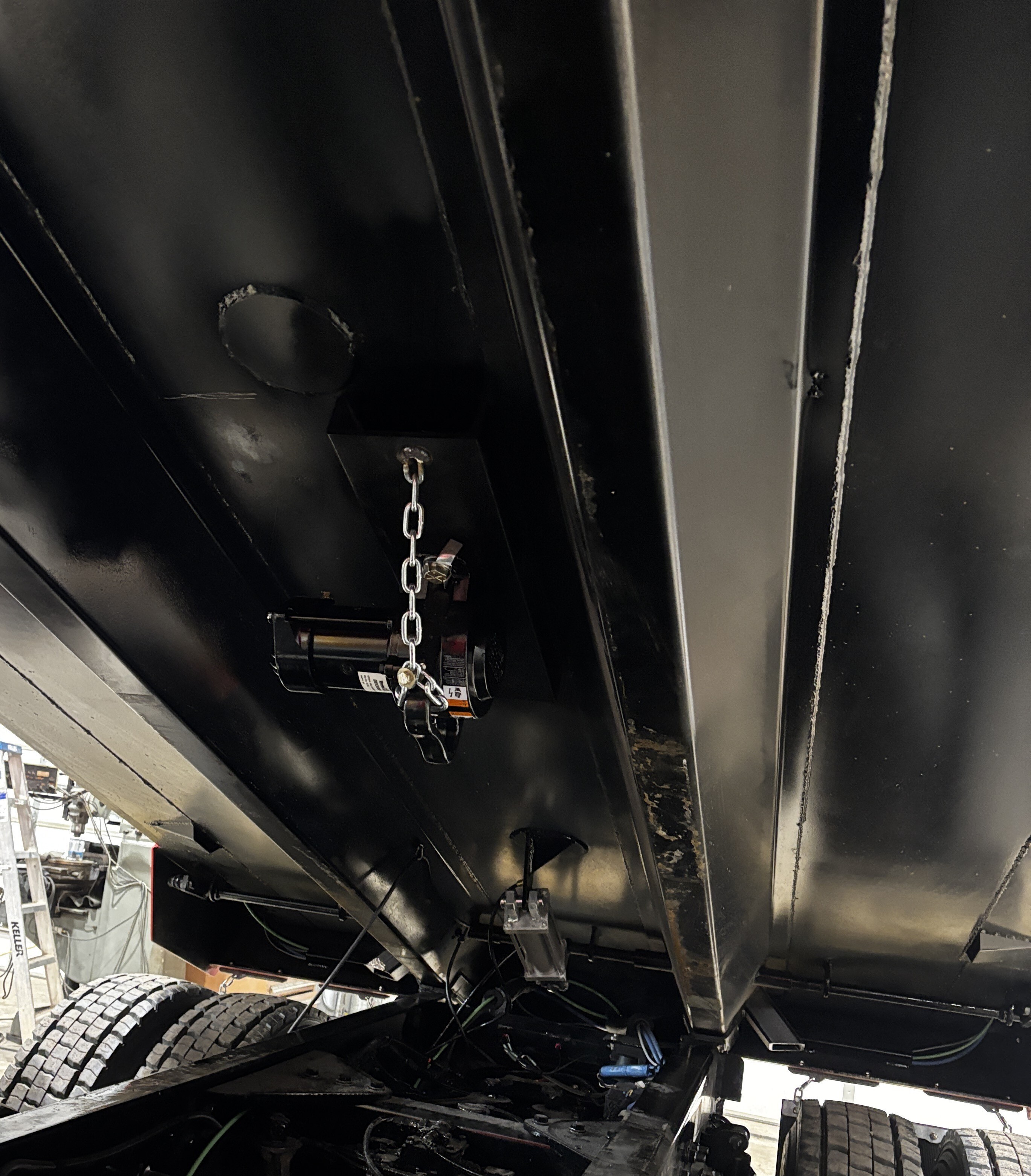 Dump body vibrator installed under dump truck body