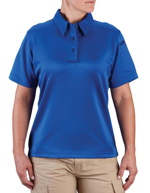 A person wears a blue collared polo shirt and beige pants, standing against a plain white background. No text is visible.