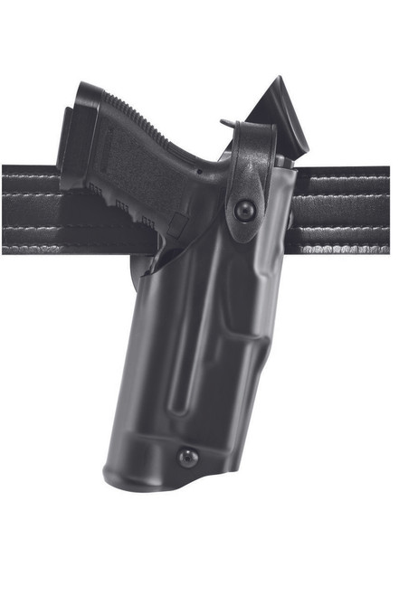 A handgun is secured in a black holster, attached to a textured black belt. The setting is plain, with a light background emphasizing the firearm and its holder.