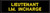 A black rectangular nameplate displays yellow text: Ã¢â‚¬Å“LIEUTENANT I.M. INCHARGE,Ã¢â‚¬Â suggesting a humorous or fictional designation within an unspecified professional or organizational setting.