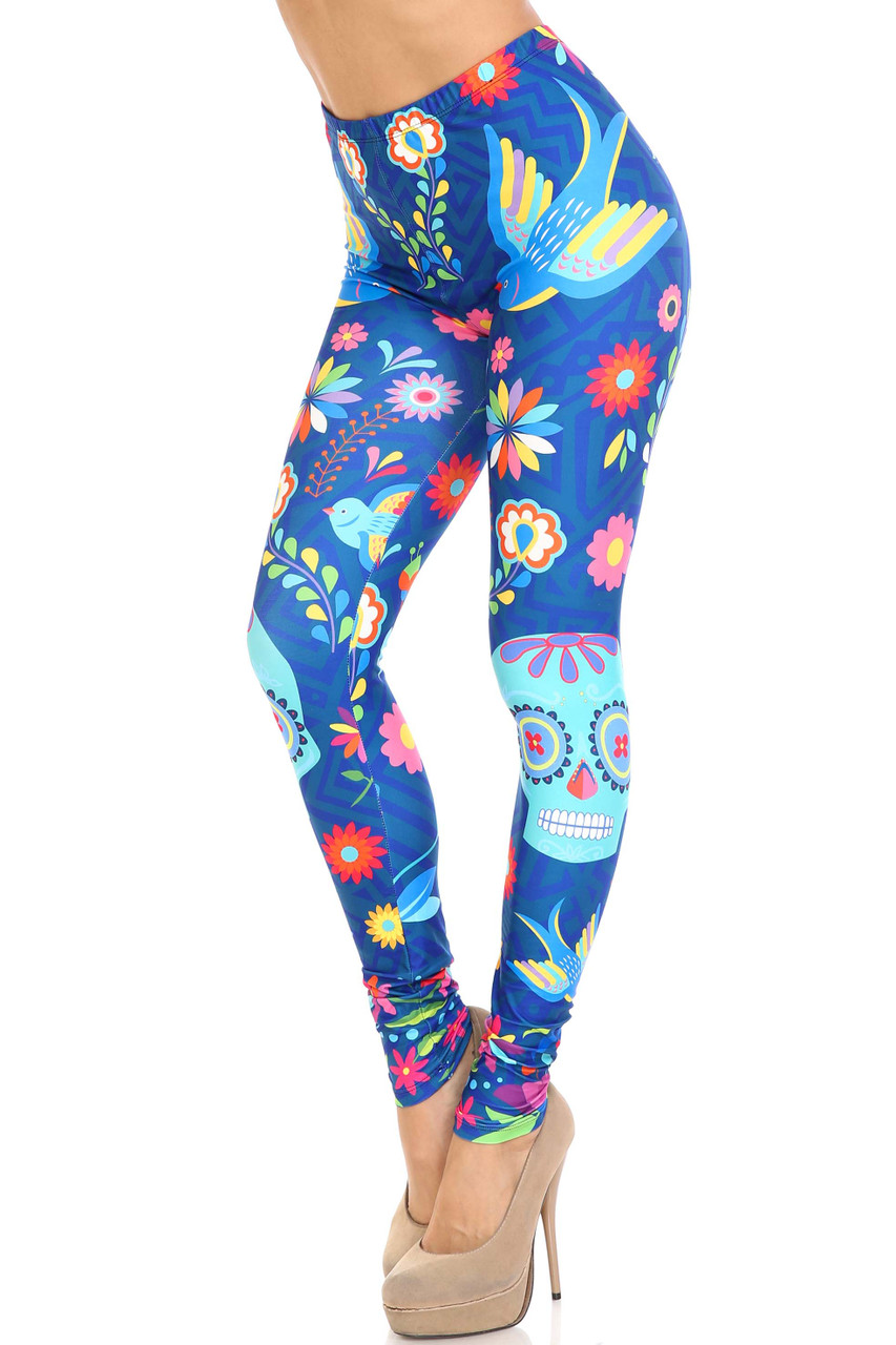 45 degree view of Creamy Soft Garden of Eden Sugar Skull Plus Size Leggings - USA Fashion™ featuring a vibrant print with sugar skulls, flowers, and birds on a blue background.