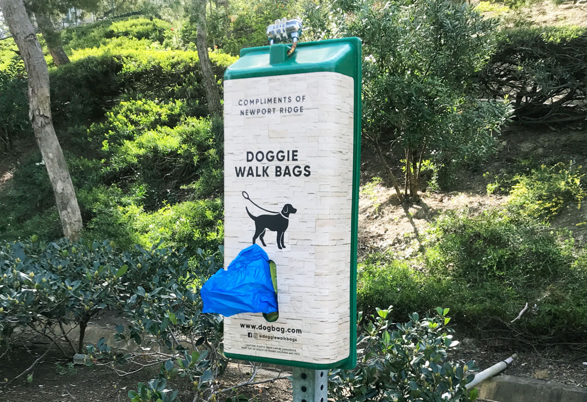 Classic dog waste bag dispenser in park with custom wrap