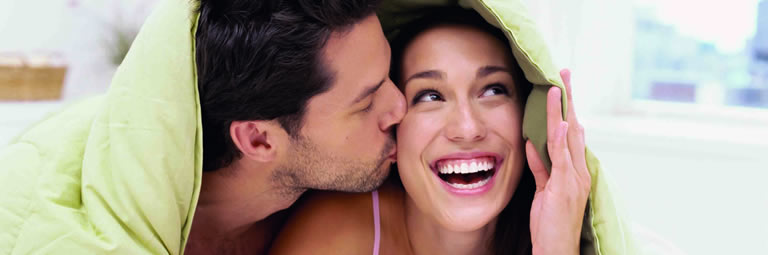 Photo of couple happily sharing a bed