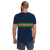 Man in a navy blue athletic t-shirt featuring green and gold stripes (rear view)