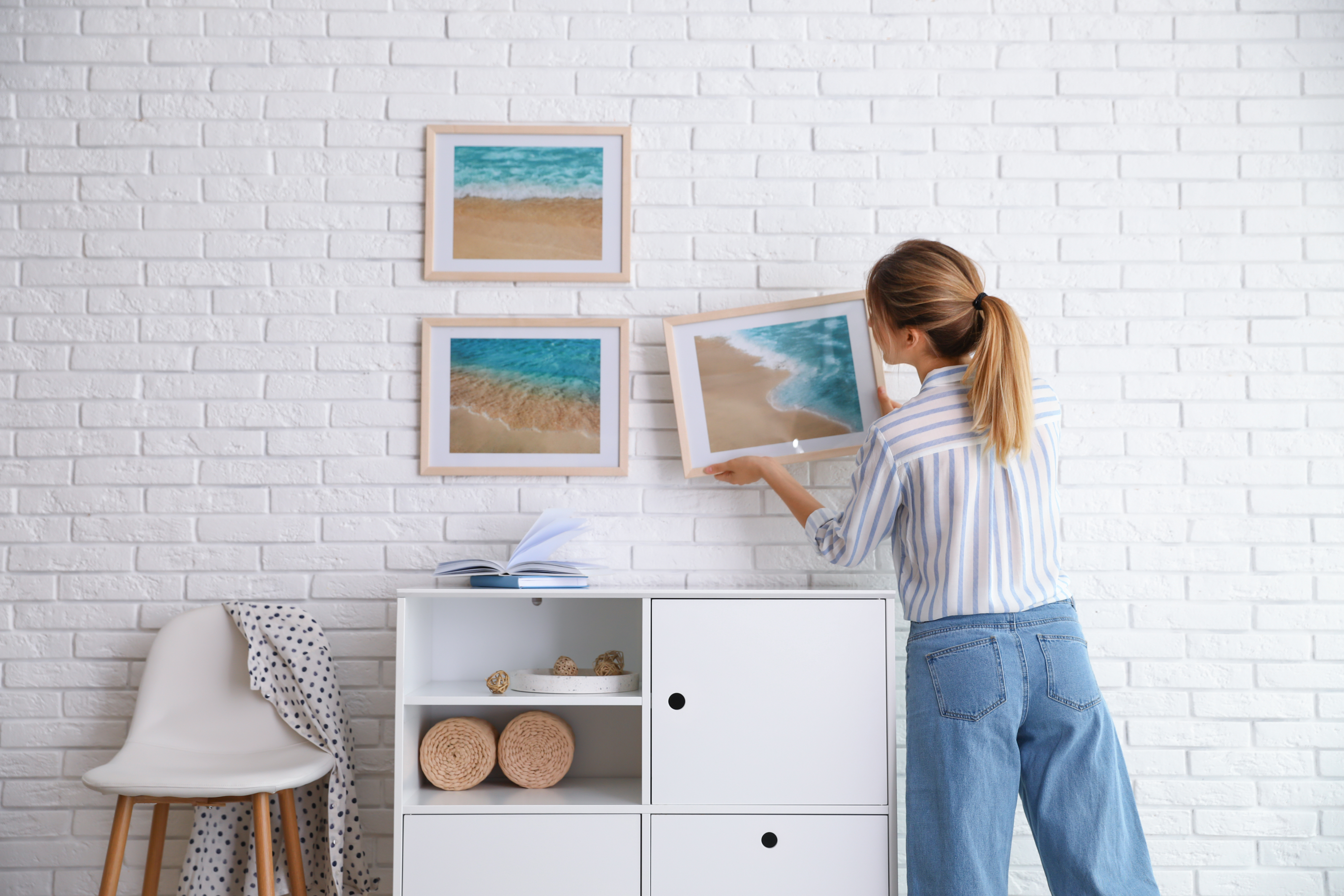 woman hanging frames