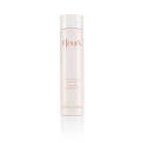 A sleek, pale bottle of body milk to oil, labeled "Fleur's Aromavedic," with a capacity of 250 ml.