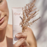 Woman holding the Smoothie Sorbet Moisturizing Cream along with a dried flower.