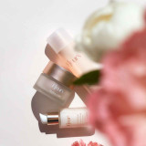 Three skincare products from Fleur's are displayed on a light background, with soft floral accents in the foreground.