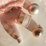 Fleur's Flora Night balm and Suprême cream sit elegantly with decorative ornaments and a patterned gift bag.