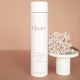 Magnolia Gentle Cleansing Milk next to a bouquet of flowers.