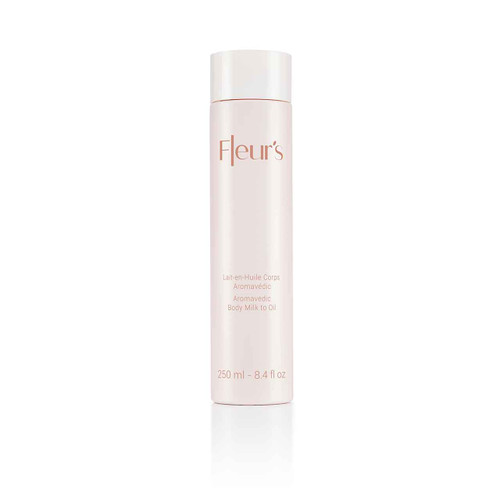 A sleek, pale bottle of body milk to oil, labeled "Fleur's Aromavedic," with a capacity of 250 ml.