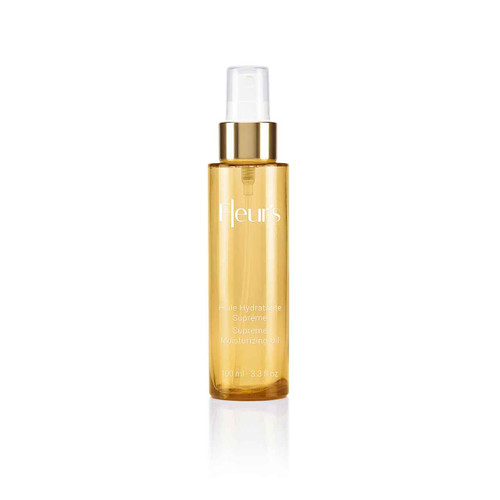 A clear bottle of moisturizing oil with a gold cap, labeled "Fleur's Huile Hydratante Suprême," 100 ml. A clear bottle of moisturizing oil with a gold cap, labeled "Fleur's Huile Hydratante Suprême," 100 ml.