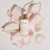 A bottle of Fleur's Floraskin Blossom Renewing Serum is surrounded by soft pink flower petals on a light background.
