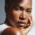 A close-up portrait of a person with smooth skin, resting their chin on their hand, with soft lighting highlighting their features.