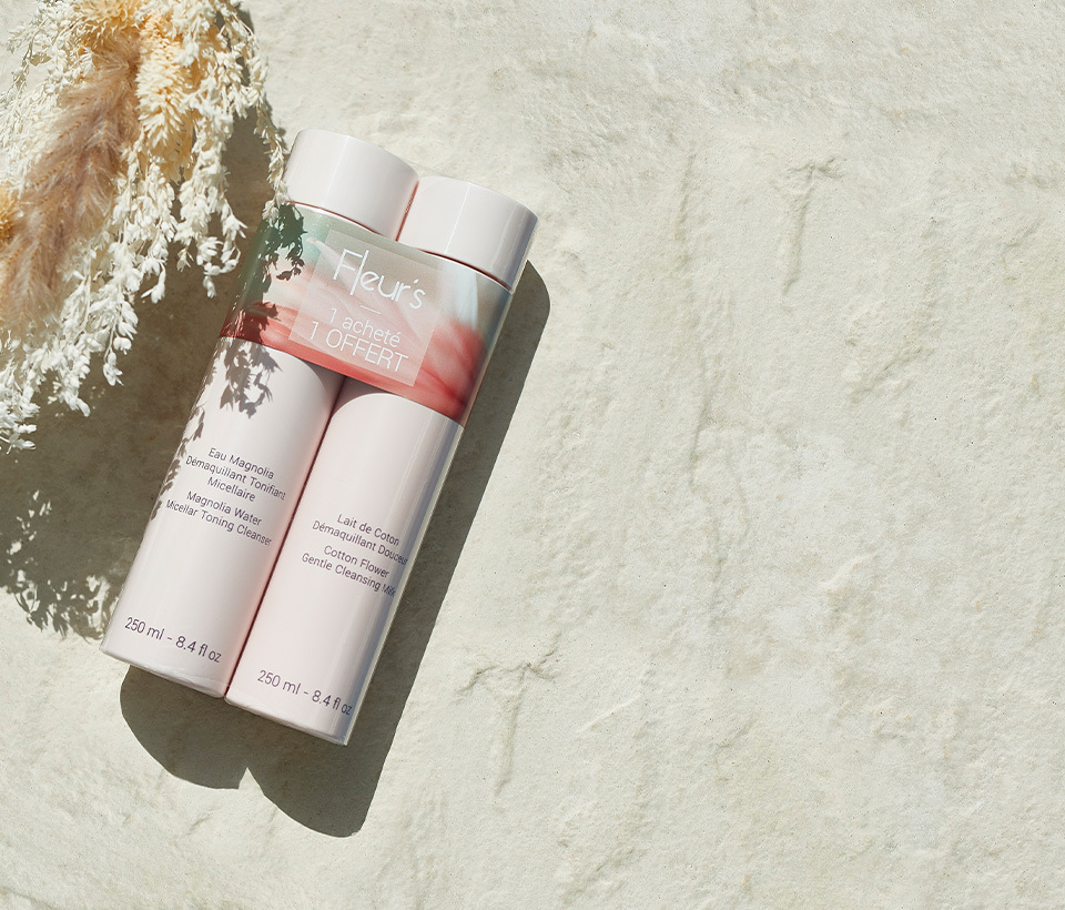 Cotton Flower Cleansing Milk 250 ml and Magnolia Water Micellar Toning Cleanser 250 ml, packaged together laying on a concrete table.