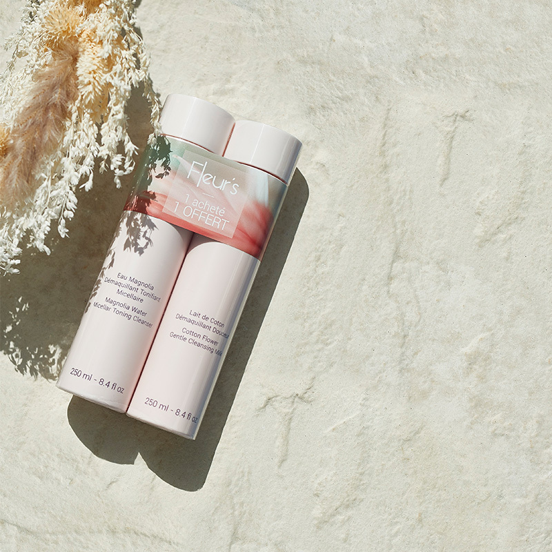 Cotton Flower Cleansing Milk 250 ml and Magnolia Water Micellar Toning Cleanser 250 ml, packaged together laying on a concrete table.