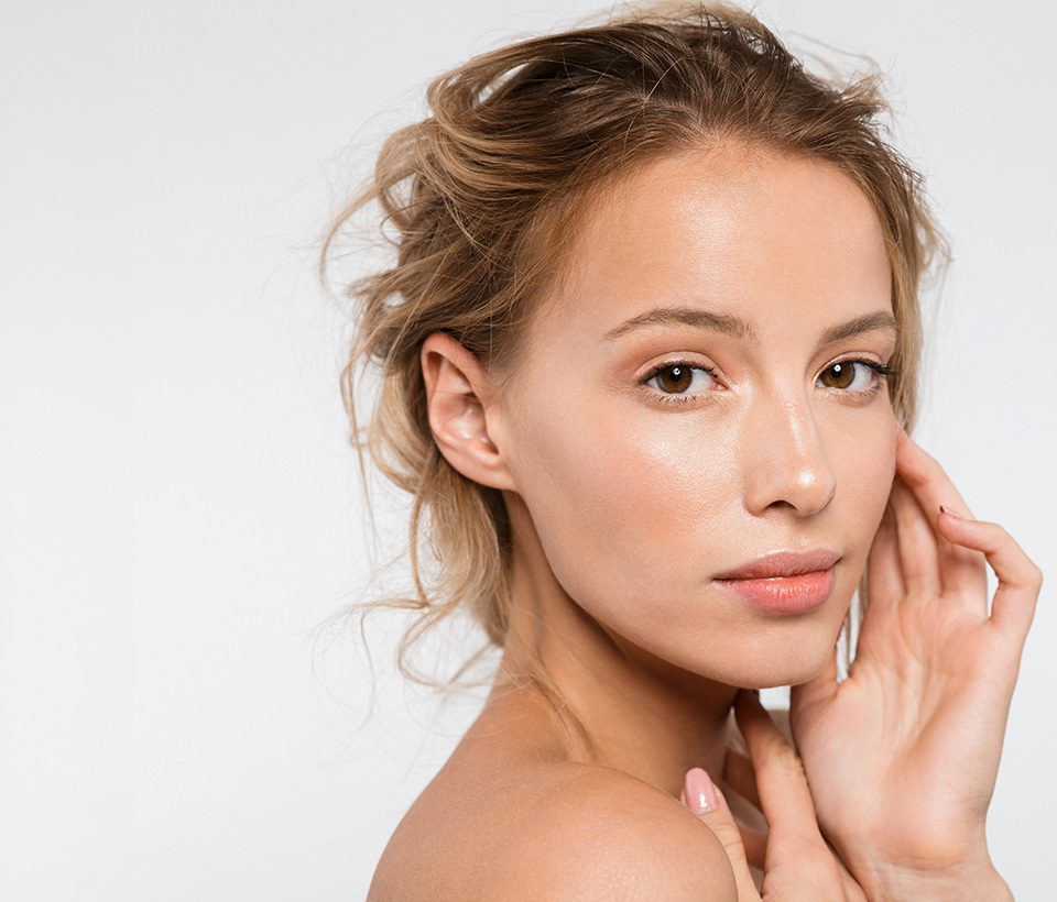 Woman caressing her cheek, gazing at the camera.