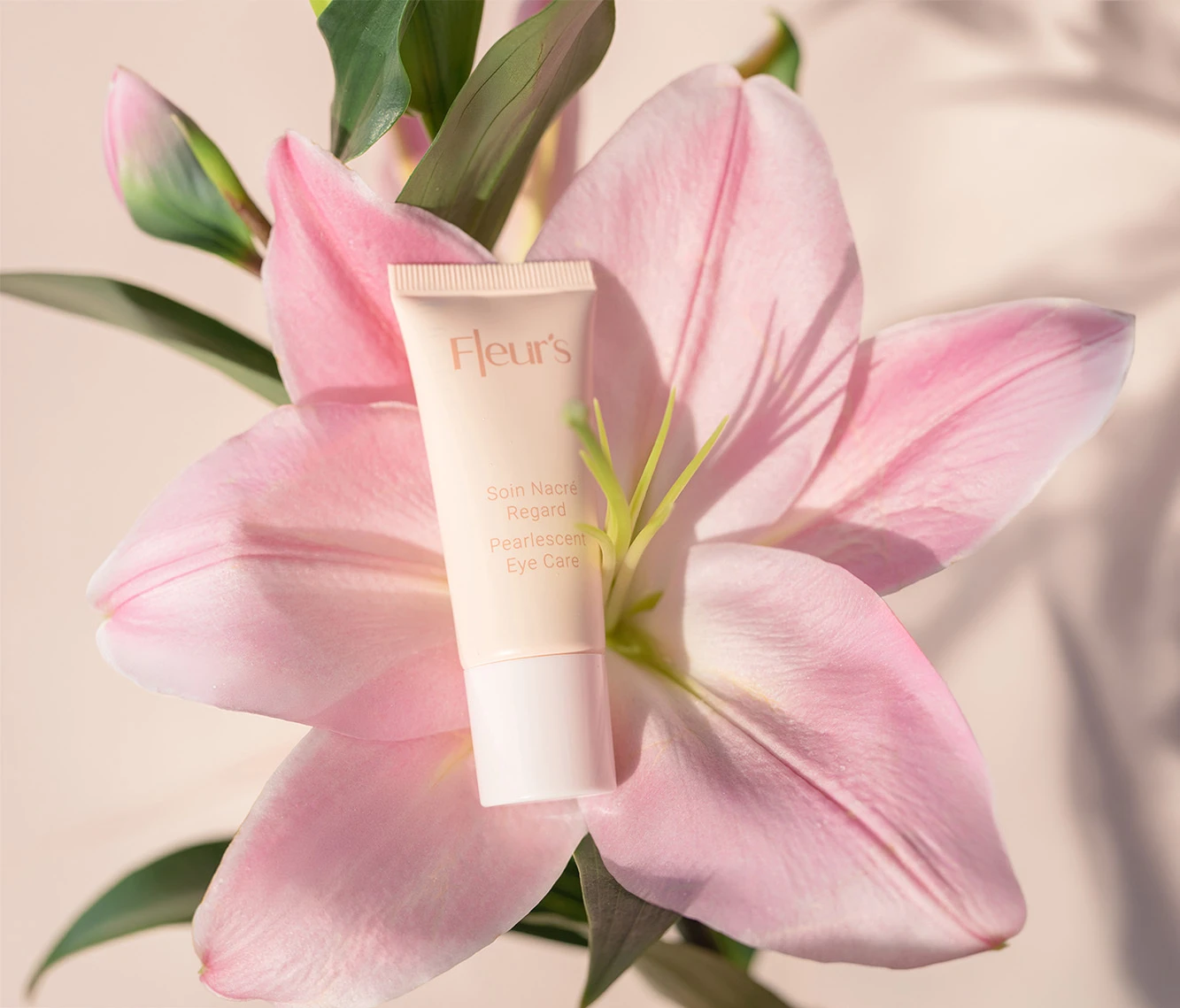 Pearlescent Eye Cream resting on a lily.