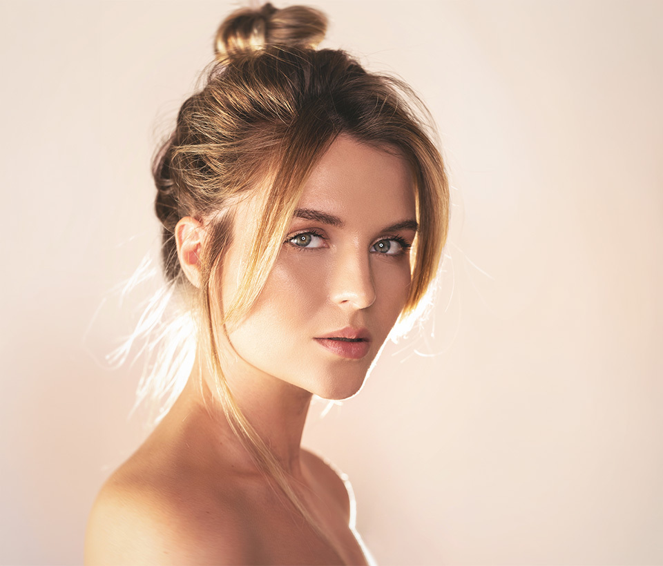 A woman gently smiling with an angelic expression. 