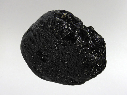 Tektites are natural glass rocks that are formed from terrestrial debris ejected during extraterrestrial impacts.