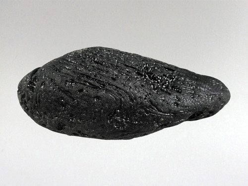 Tektites are natural glass rocks that are formed from terrestrial debris ejected during extraterrestrial impacts.